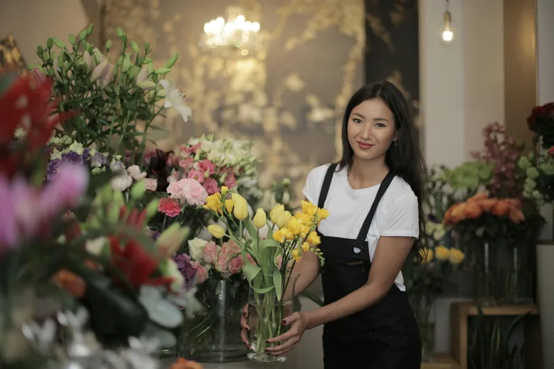 A skilled FloweryStore florist carefully arranging a stunning bouquet of fresh flowers in the shop